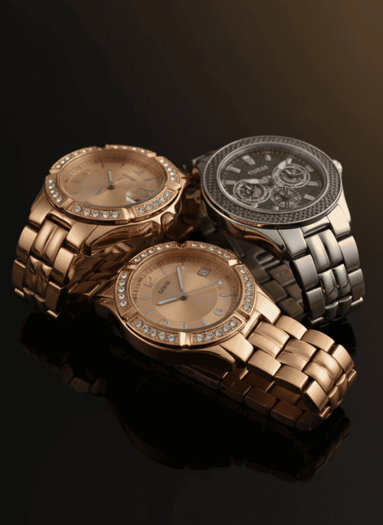 Three Guess watches on a glossy dark surface